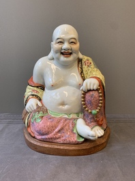 A large Chinese famille rose Milefo Buddha on wooden stand, 20th C.