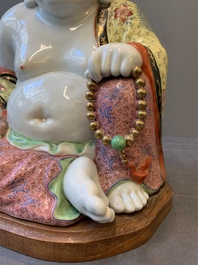 A large Chinese famille rose Milefo Buddha on wooden stand, 20th C.