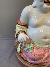 A large Chinese famille rose Milefo Buddha on wooden stand, 20th C.