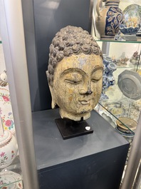 A large Chinese stone head of Buddha with traces of gilding and polychromy, Ming
