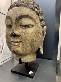 A large Chinese stone head of Buddha with traces of gilding and polychromy, Ming