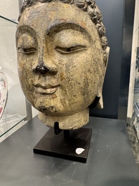 A large Chinese stone head of Buddha with traces of gilding and polychromy, Ming