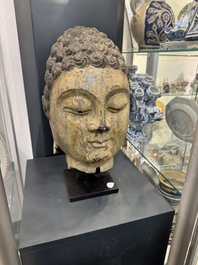 A large Chinese stone head of Buddha with traces of gilding and polychromy, Ming