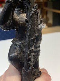 A Chinese bronze incense holder of a boy standing on a lotus, Ming