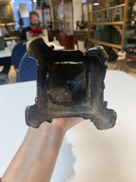 A Chinese bronze incense holder of a boy standing on a lotus, Ming