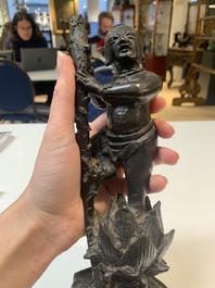 A Chinese bronze incense holder of a boy standing on a lotus, Ming