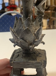 A Chinese bronze incense holder of a boy standing on a lotus, Ming