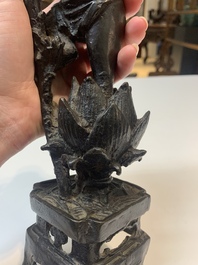 A Chinese bronze incense holder of a boy standing on a lotus, Ming