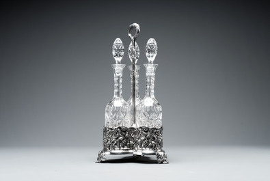 A sterling silver tantalus with three crystal-cut bottles and stoppers, 19/20th C.