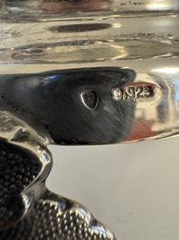 A sterling silver tantalus with three crystal-cut bottles and stoppers, 19/20th C.