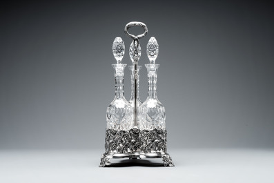 A sterling silver tantalus with three crystal-cut bottles and stoppers, 19/20th C.