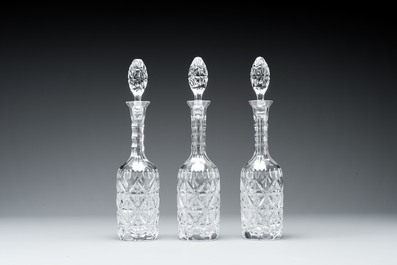 A sterling silver tantalus with three crystal-cut bottles and stoppers, 19/20th C.