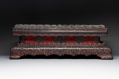 A Chinese rectangular carved red and black lacquer stand, 20th C.