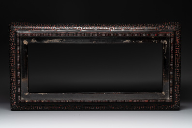 A Chinese rectangular carved red and black lacquer stand, 20th C.