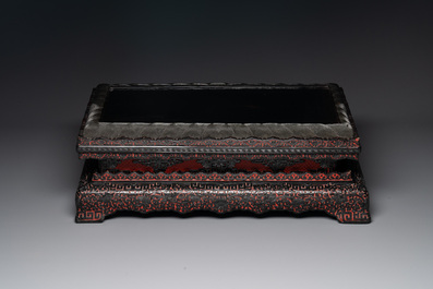 A Chinese rectangular carved red and black lacquer stand, 20th C.