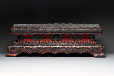 A Chinese rectangular carved red and black lacquer stand, 20th C.
