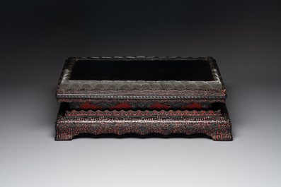 A Chinese rectangular carved red and black lacquer stand, 20th C.