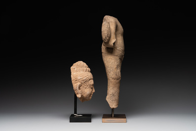 A sandstone torso and a Buddha head, Cambodia, late Khmer period, 13/14th C.