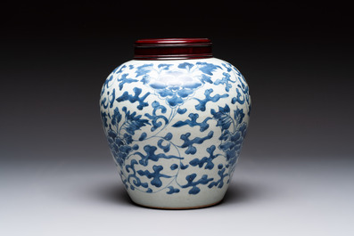 A Chinese blue and white 'peony scrolls' vase and wooden cover, Transitional period
