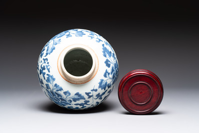 A Chinese blue and white 'peony scrolls' vase and wooden cover, Transitional period