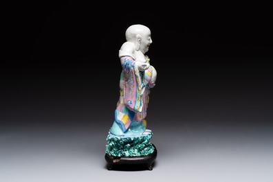 A Chinese famille rose Milefo Buddha on wooden stand, 19th C.