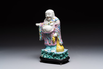 A Chinese famille rose Milefo Buddha on wooden stand, 19th C.