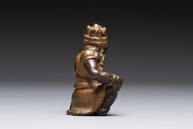 A small Chinese gilt bronze paperweight in the form of a kneeling foreigner, Ming