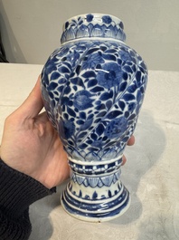 A pair of Chinese blue and white vases and covers with floral design, Kangxi