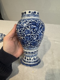 A pair of Chinese blue and white vases and covers with floral design, Kangxi