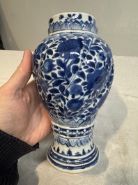 A pair of Chinese blue and white vases and covers with floral design, Kangxi