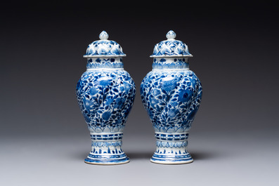 A pair of Chinese blue and white vases and covers with floral design, Kangxi