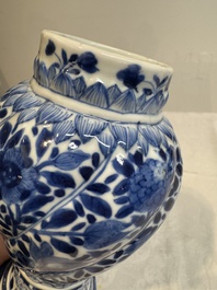 A pair of Chinese blue and white vases and covers with floral design, Kangxi