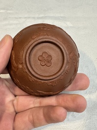 A Chinese Yixing stoneware cup and saucer with plum blossom relief design, Kangxi