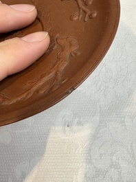 A Chinese Yixing stoneware cup and saucer with plum blossom relief design, Kangxi