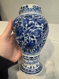 A pair of Chinese blue and white vases and covers with floral design, Kangxi