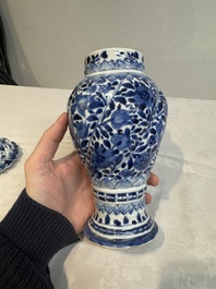 A pair of Chinese blue and white vases and covers with floral design, Kangxi