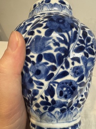 A pair of Chinese blue and white vases and covers with floral design, Kangxi