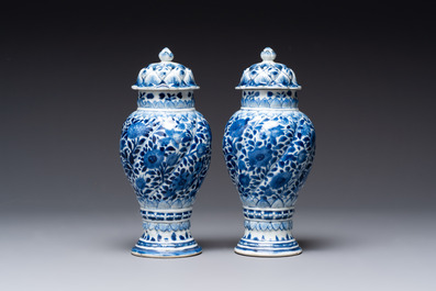 A pair of Chinese blue and white vases and covers with floral design, Kangxi