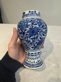 A pair of Chinese blue and white vases and covers with floral design, Kangxi