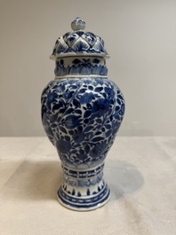 A pair of Chinese blue and white vases and covers with floral design, Kangxi