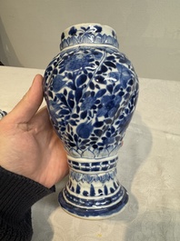 A pair of Chinese blue and white vases and covers with floral design, Kangxi