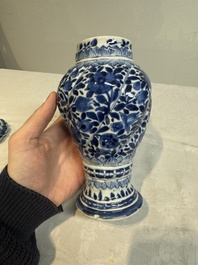 A pair of Chinese blue and white vases and covers with floral design, Kangxi