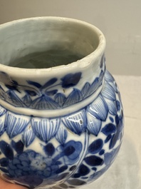 A pair of Chinese blue and white vases and covers with floral design, Kangxi
