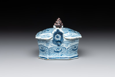 A blue and white Dutch Delft butter tub and cover with a berry finial, 18th C.