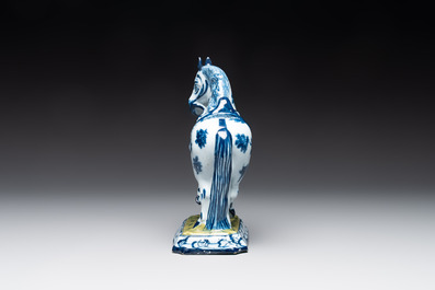 A fine pair of blue and white Dutch Delft horses on a green base, 18th C.