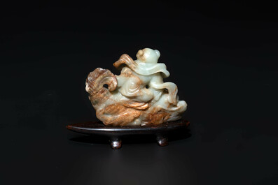 A Chinese celadon and russet jade figure of a boy riding a dragon carp, Qing