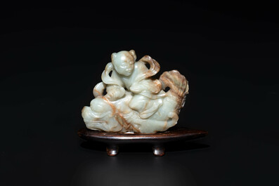 A Chinese celadon and russet jade figure of a boy riding a dragon carp, Qing