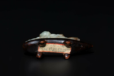 A Chinese celadon and russet jade figure of a boy riding a dragon carp, Qing