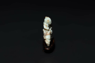 A Chinese celadon and russet jade figure of a boy riding a dragon carp, Qing