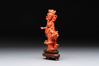 A Chinese red coral figure of a goddess on wooden stand, 19/20th C.